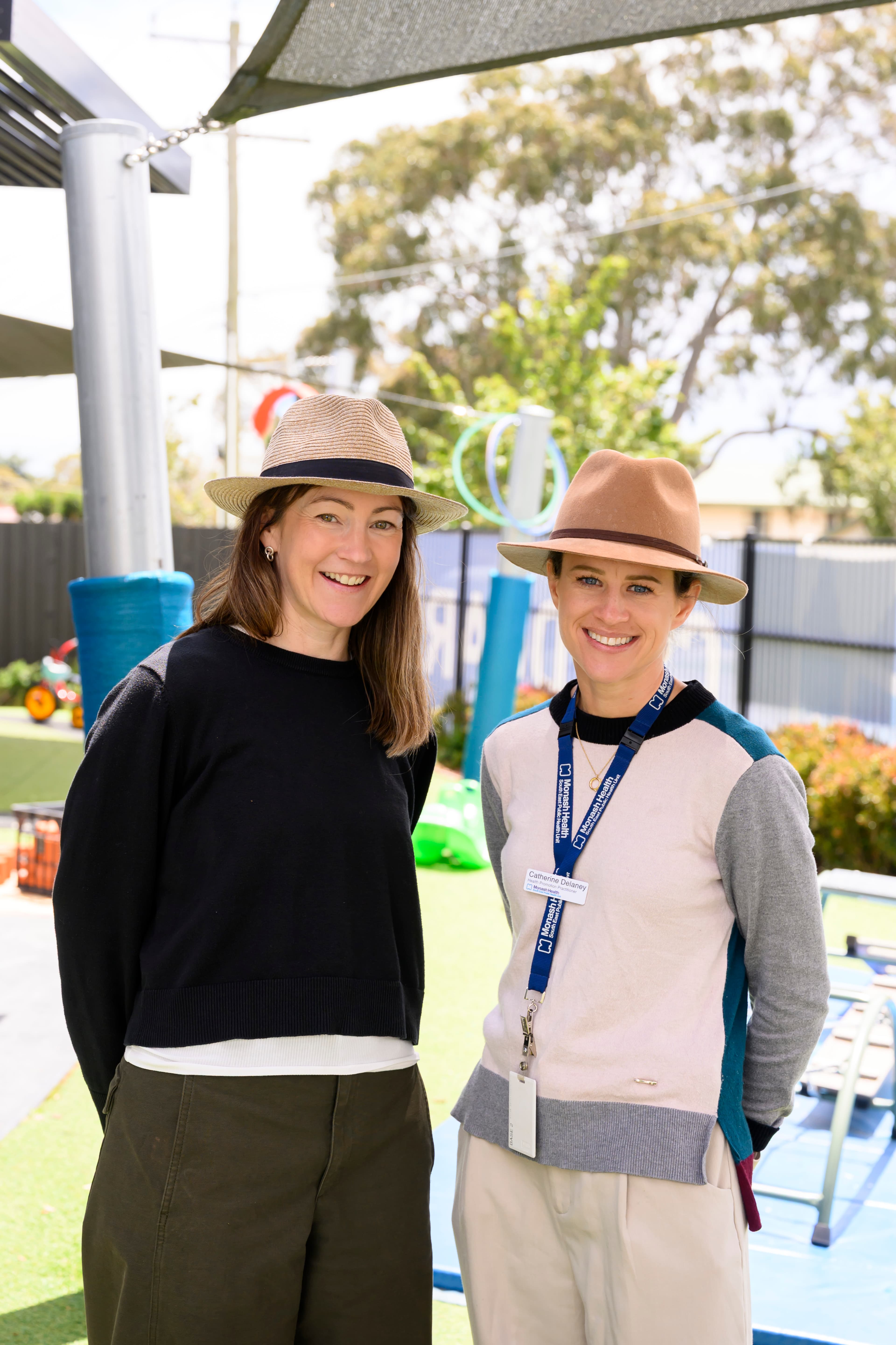 Two people standing outside smiling