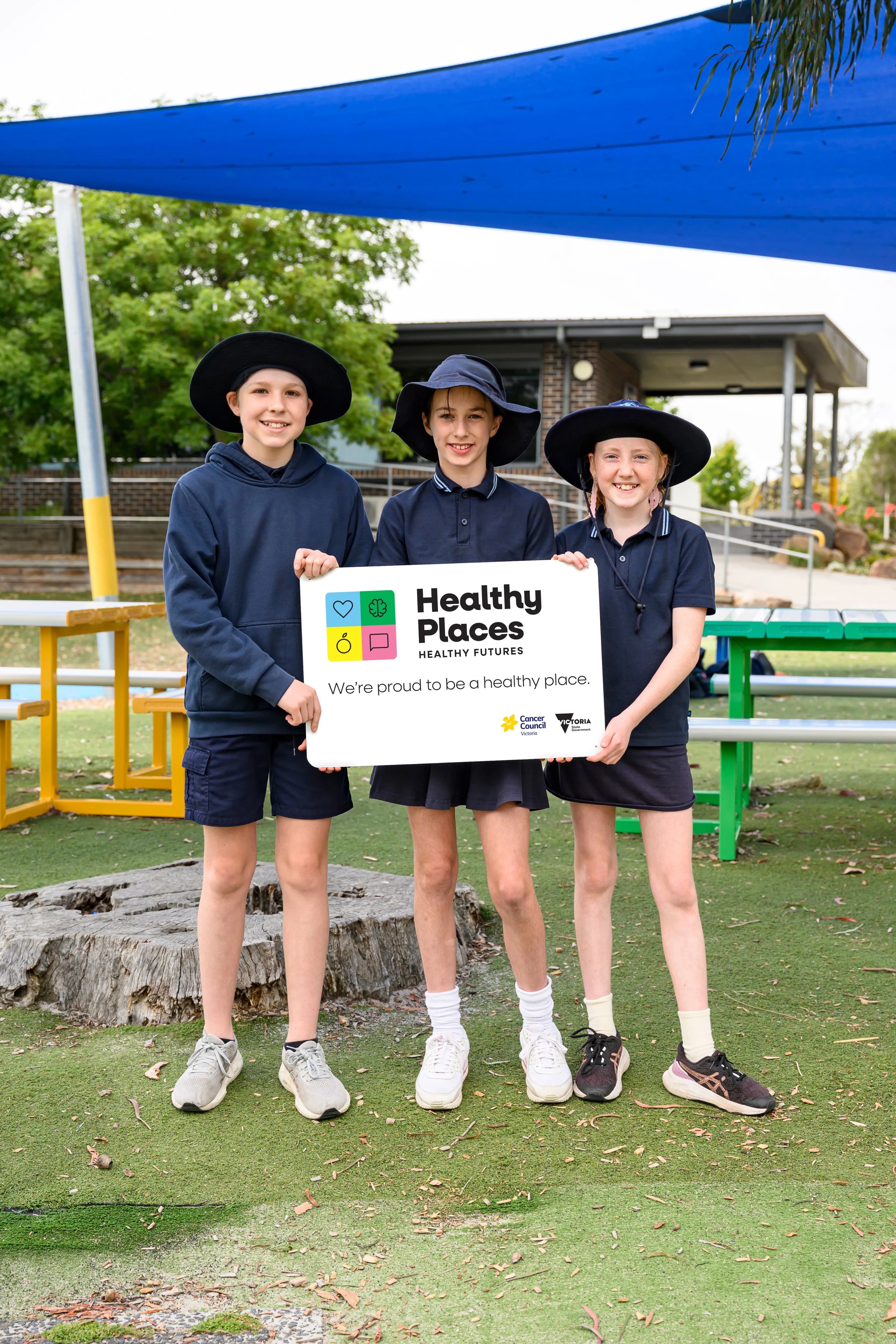 school students holding a sign displaying the Healthy Places Healthy Futures brand
