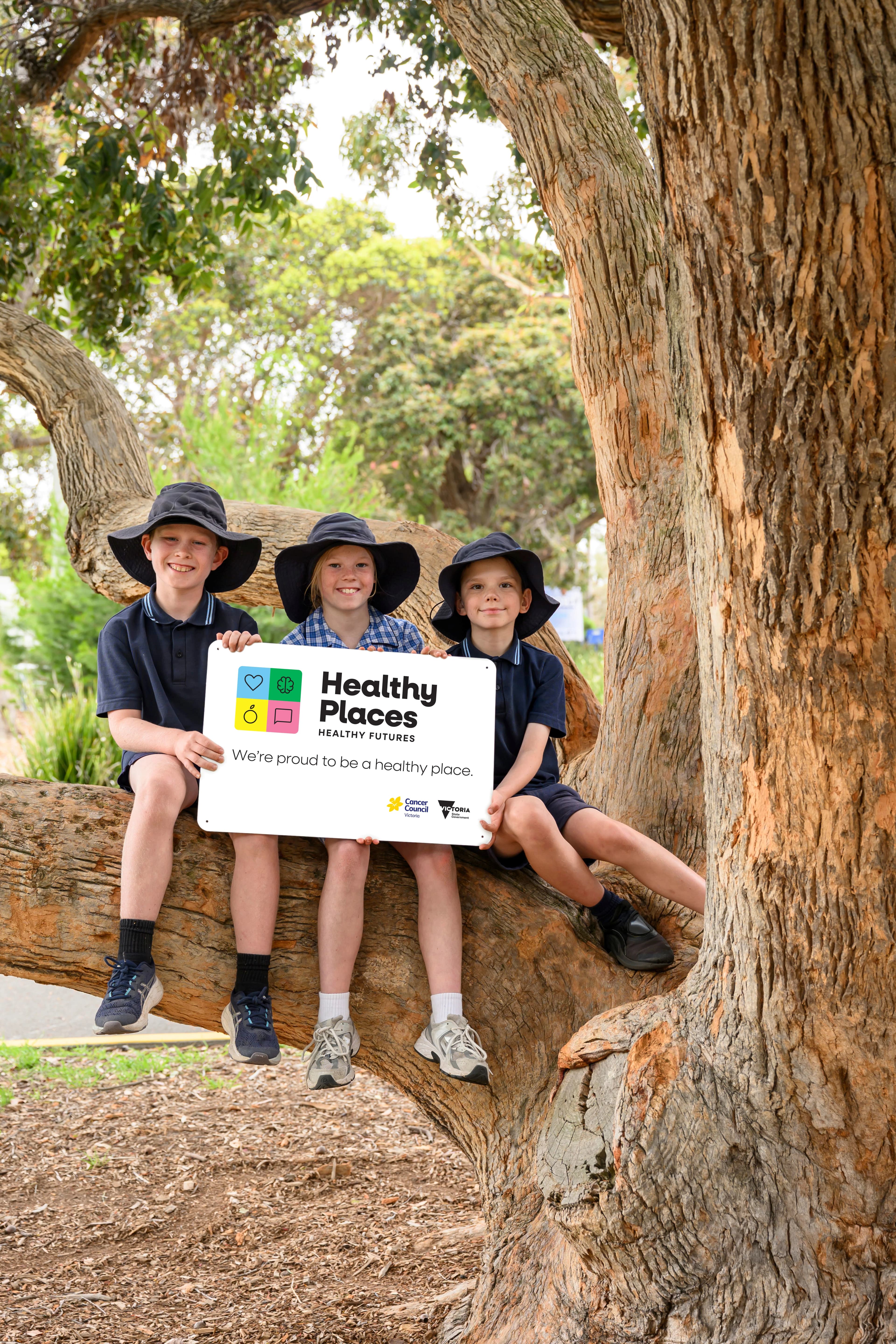 school students holding a sign displaying the Healthy Places Healthy Futures brand